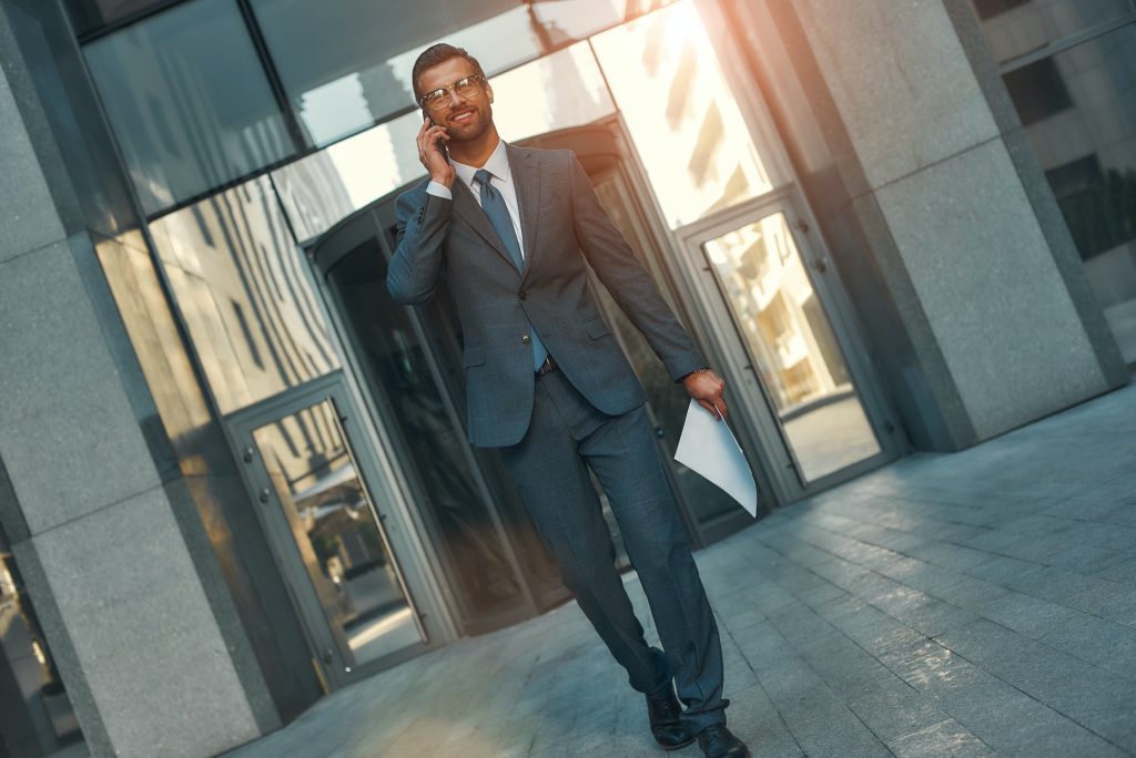 Happy to hear you Portrait of smiling bearded businessman in full suit talking by phone with client